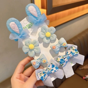 Dettaglio del set da 7 pezzi di mollette per capelli celesti con fiori, fiocchi e conigli