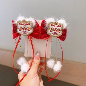Détail de pinces à cheveux rouges pour le Nouvel An avec broderie lion et pompons