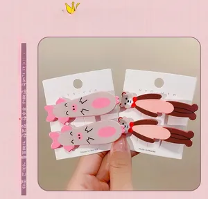 Detail of four cute animal hair clips featuring pink pigs and brown bears with red bows