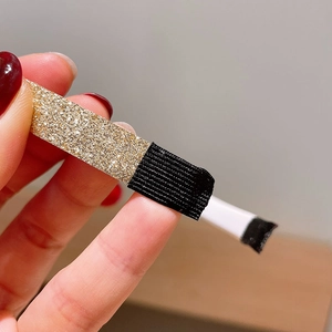 Macro d'une pince à cheveux à paillettes dorées avec bande élastique noire