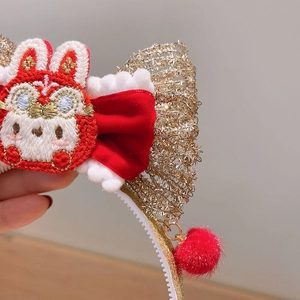 Détail de pince à cheveux de Nouvel An avec lapin brodé, nœud rouge festif et pompon en peluche