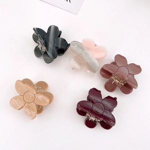 Detail view of 5-piece floral acetate hair claw set in marble and solid finishes