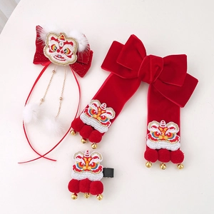 Détail des pinces à cheveux de fête chinoise avec broderie de lion et pompons rouges