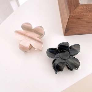 Close-up of handmade floral acetate hair claws in pink and black marble textures