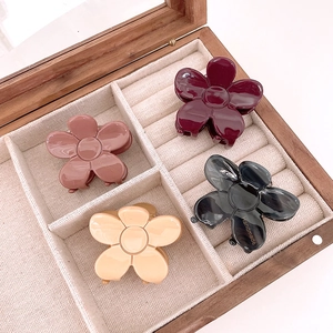 Set of floral acetate hair claws in four colors displayed in a wooden jewelry box