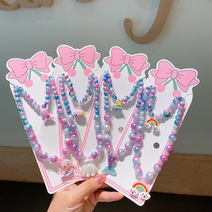 Detail of colorful mermaid and seashell beaded jewelry sets for girls on pink bow cards