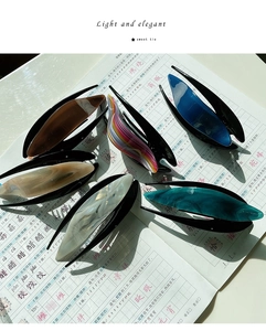 Close-up of six textured acetate banana hair clips in diverse marble and amber patterns