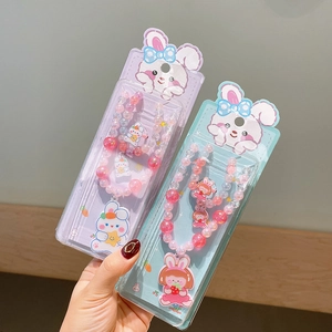 Detail of colorful beaded necklace and ring set with cute cartoon pendants in retail packaging