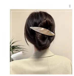 Detail showing marble texture beige hair claw clip on hair bun from back view