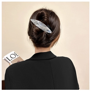 Detailed view of large silver hair claw clip with irregular fluid design in dark hair