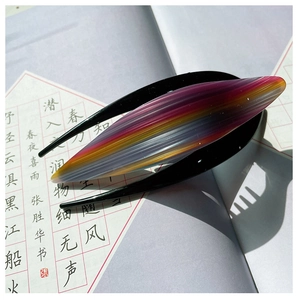 Close-up of sleek acetate hair claw clip with colorful gradient stripes and glossy finish