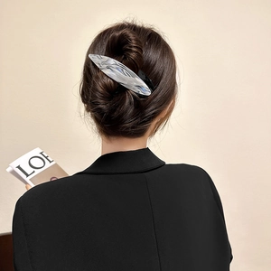 Elegant silver acetate hair claw clip with water ripple texture worn by a model