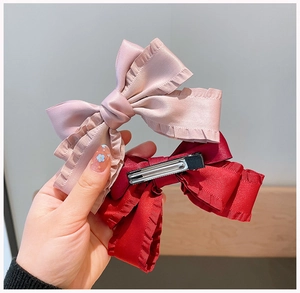 Detailed macro view of handmade vintage bow hair clips with premium matte satin fabric texture