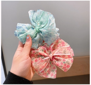 Détail des barrettes à cheveux en mousseline fleurie bleue et rose pour filles