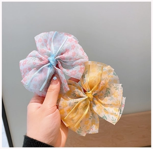 Gros plan de barrettes à cheveux en mousseline florale avec texture organza et motifs imprimés
