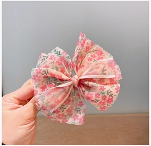 Vue détaillée d'une barrette à cheveux en mousseline rose avec motifs floraux fins