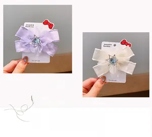 Detail van organza haarclip met zeeblauw kristal en zilveren kroon in het midden