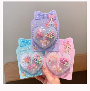 Detail of colorful acrylic flower beads in heart-shaped box for kids DIY jewelry sets