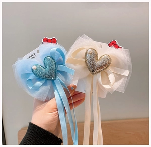 Dettaglio di fermagli per capelli con nastri lunghi, paillettes e perle lucide