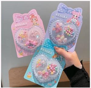 Handheld view of a children's DIY beaded jewelry set with colorful flower acrylic beads