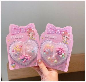 Close-up of kids DIY jewelry kit featuring colorful flower beads in pink heart packaging
