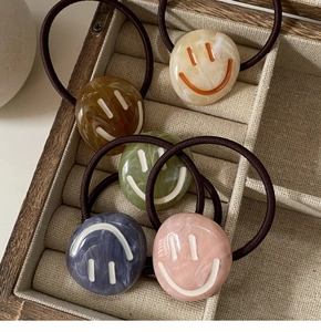 Detail of high-elasticity hair ties with marble-textured smile face acrylic charms