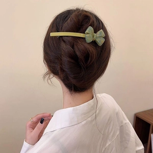 Elegant light green marble resin bow hair clip styled on a woman's brown updo hairstyle
