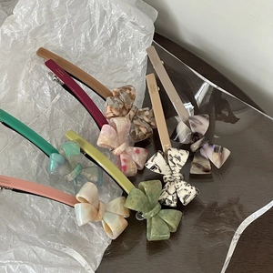 Close-up of handmade acetate bow hair clips in multiple colors with France engraving