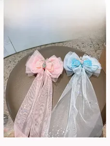Dettaglio di fiocchi per capelli in rete glitter con corone e lunghe nappe di paillettes