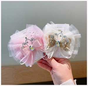 Dettaglio di fermagli per capelli in tulle stratificato con corona e paillettes rosa