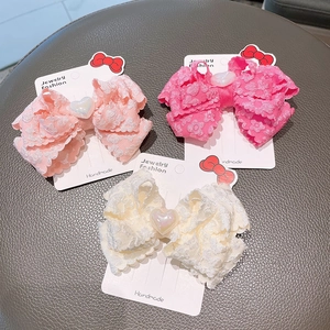 Detail of 3D embossed double-layered bow hair clips with heart resin gems on cards