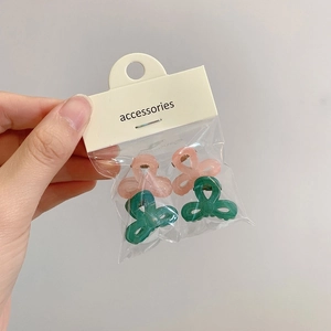 Makroansicht von 4-teiligen matten Mini-Haarspangen in Rosa und Grün im Set
