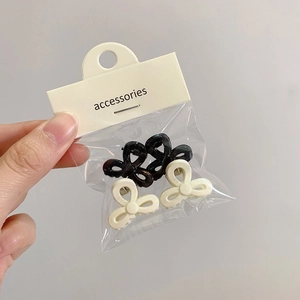 Vierer-Set Mini-Blumenhaarklammern in Schwarz und Cremeweiß auf Zubehör-Displaykarte