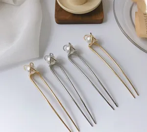 Detailed view of elegant gold and silver U-shaped hair pins with white pearls on top