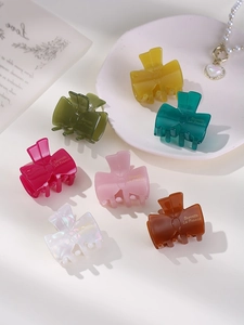 Detail view of colorful bow-shaped jelly hair clips in various vibrant acetate colors