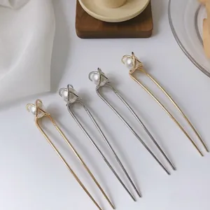 Elegant U-shaped hair pins set with pearls in gold and silver finish on silk background