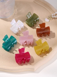Close-up of assorted jelly-colored bow-shaped hair clips in various bright hues