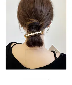 Barrette à cheveux classique en acétate ambre avec huit perles sur un chignon bas