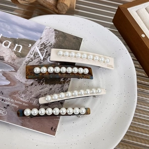 Détail des barrettes en acétate crème et écaille de tortue avec perles incrustées