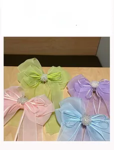 Détail macro de barrettes à cheveux en organza avec perles et rubans pastel