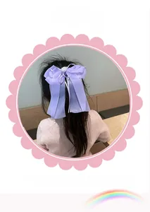 Détail d'un grand nœud papillon violet en organza avec une perle blanche centrale