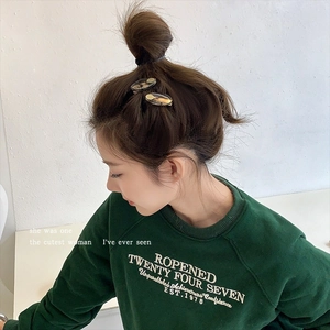 Close-up of stylish amber textured acetate hair clips worn on model side hairstyle