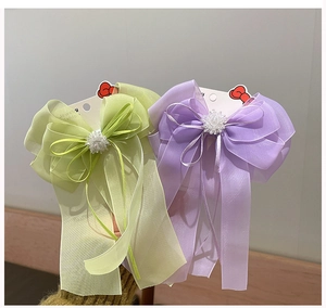 Détail de nœuds à cheveux en organza vert clair et lavande avec centres perlés
