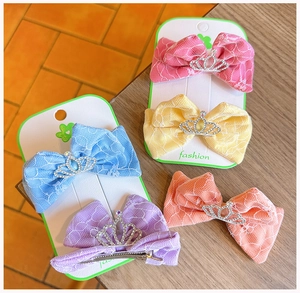 Detalle de pinzas para el cabello con lazos de encaje y coronas de pedrería