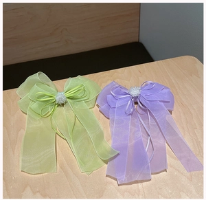 Détail de nœuds à cheveux en organza avec perles et rubans en vert et lavande doux