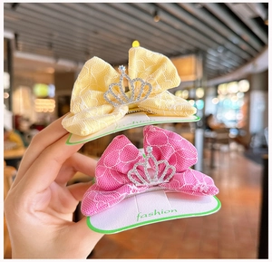 Detalle de pinzas para el cabello con lazos de encaje amarillo y rosa con coronas