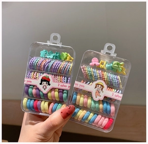 Close-up of children's colorful elastic hair ties and cute clips in a clear storage box
