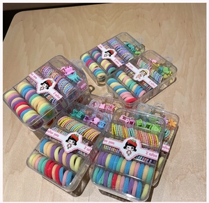 Close-up of candy colored elastic hair ties and mini hair clips in transparent gift boxes