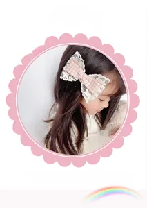Close-up of pink checkered bow hair clip with white lace trim for girls