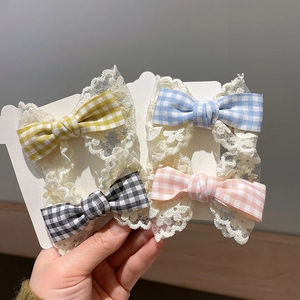 Set of four gingham and lace bow hair clips in yellow, blue, black, and pink colors